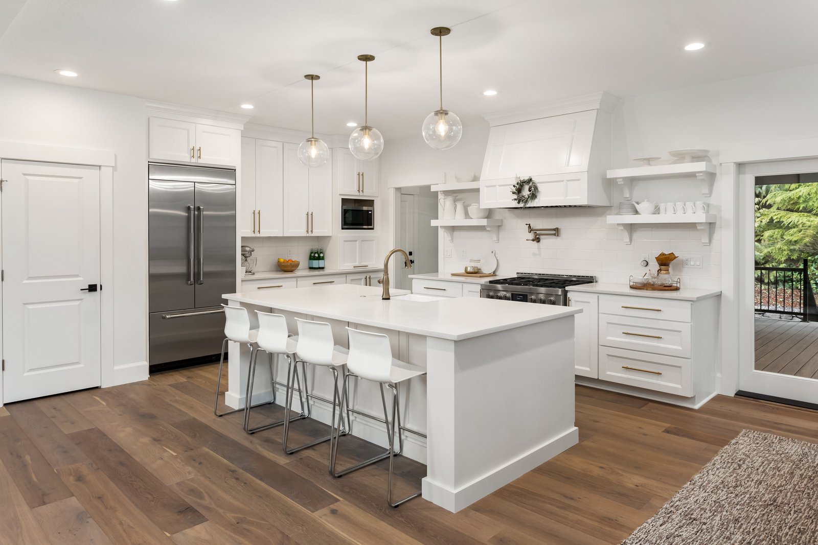 beautiful kitchen in new luxury home with island, pendant lights, and hardwood floors